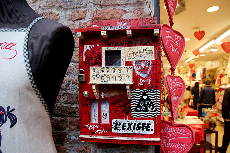 A red mailbox covered in love notes is Juliet's Mailbox and is located in the courtyard of Juliet's house