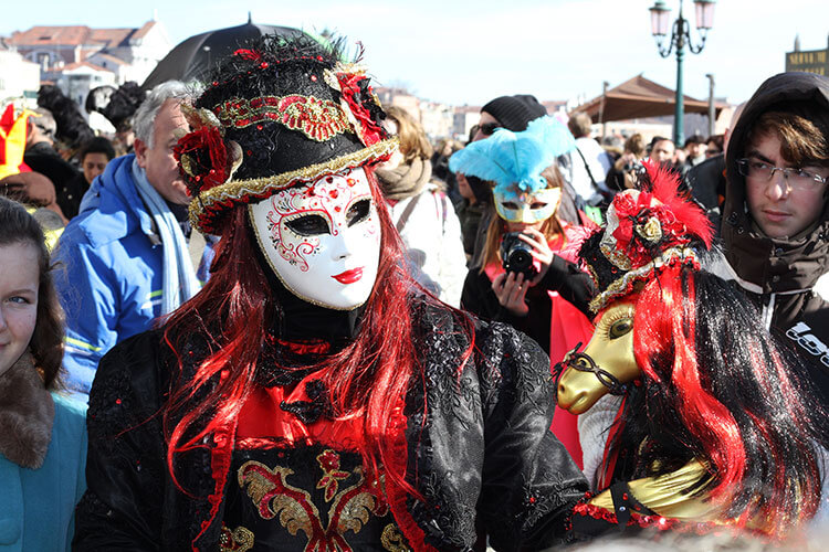 A group of people wearing Venetian Carnival Masks, engaging in a