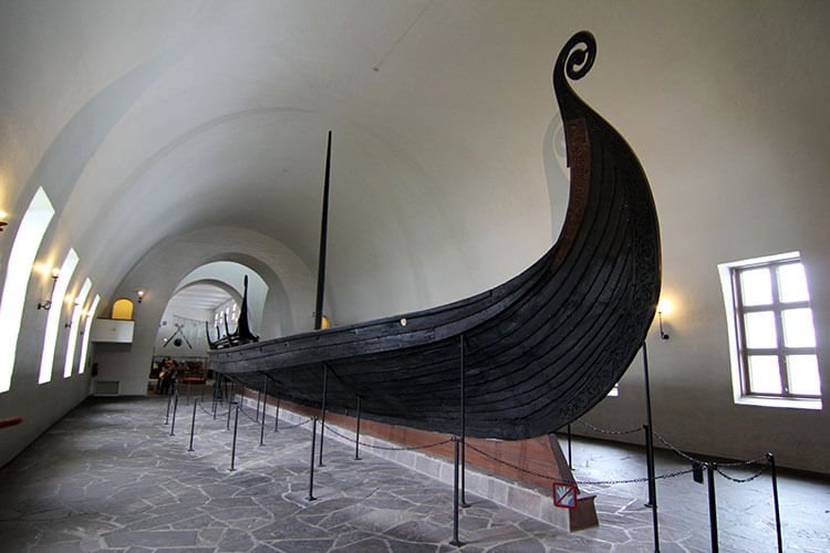 The dark wood Oseberg Ship with its curled bow 