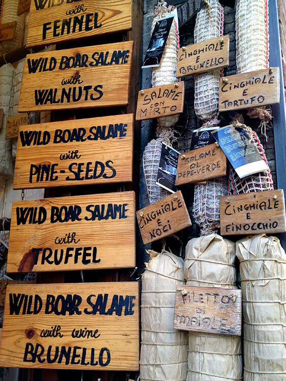 A salami shop with various types of wild boar salami hanging in San Gimignano