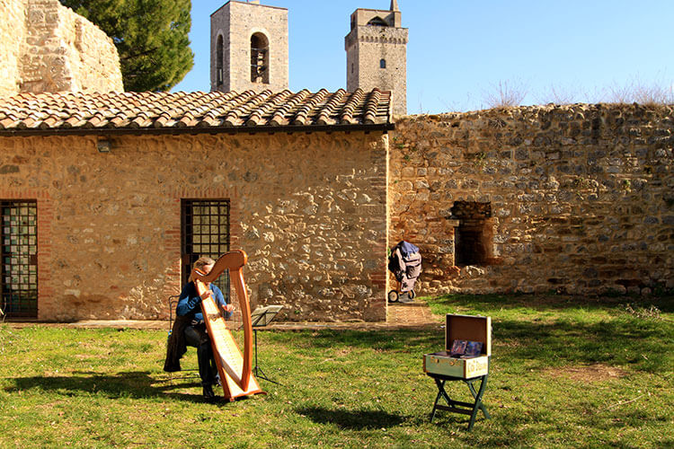 A harpist plays a harp in La Rocca fortress at the top of the hilltop town of San Gimignano