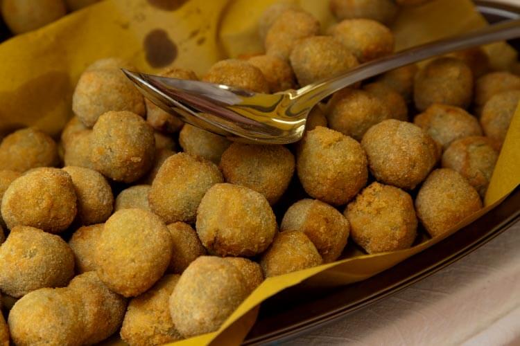 Fried olives are ready to be sold in paper cones at a market in Italy