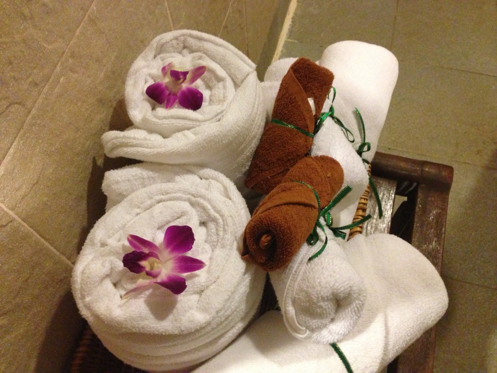 Towels and bathrobes are rolled up and decorated with orchids