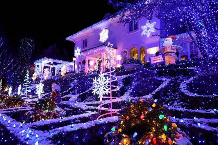 The Blue Christmas House with all blue lights on the lawn, in the trees and around the windows with snowflakes and snowmen