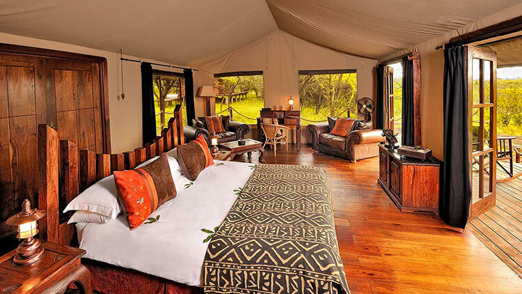 Inside our Serengeti Migration Camp luxury safari tent with king size bed, leather furniture and hard wood floor