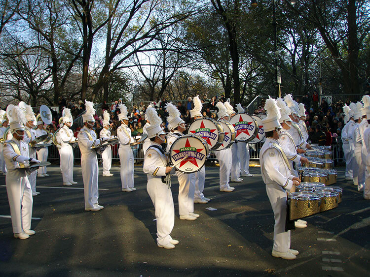 Marching band at Macy's Thanksgiving Day Parade passes through Columbus Circle