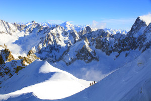 Off-piste skiers make their way down the ridge from Aiguille du Midi on Mont Blanc