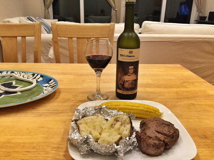 My steak, baked potato and corn on the cob with a bottle of wine that I cooked at the Sandy Toes cottage on Rose Island, Bahamas