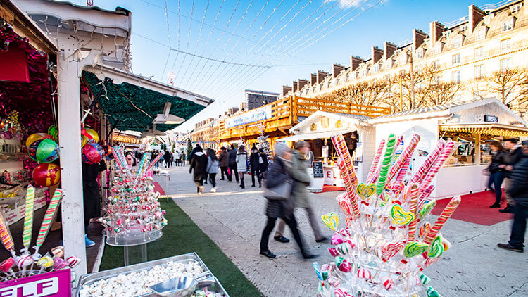 Massive candy canes are sold from one of the wooden huts at the Christmas market in the Jardin des Tuileries in Paris