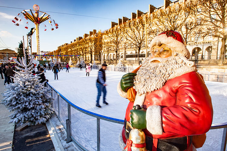 Skaters ice skate on the outdoor rink at Jardin des Tuileries in Paris, France