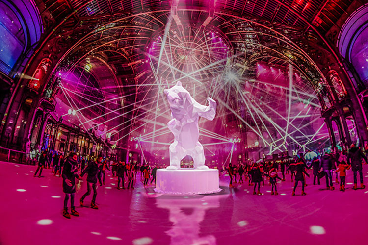 A bear snow sculpture stands in the center of the massive 3000 square meter ice rink at the Grand Palais in Paris, France