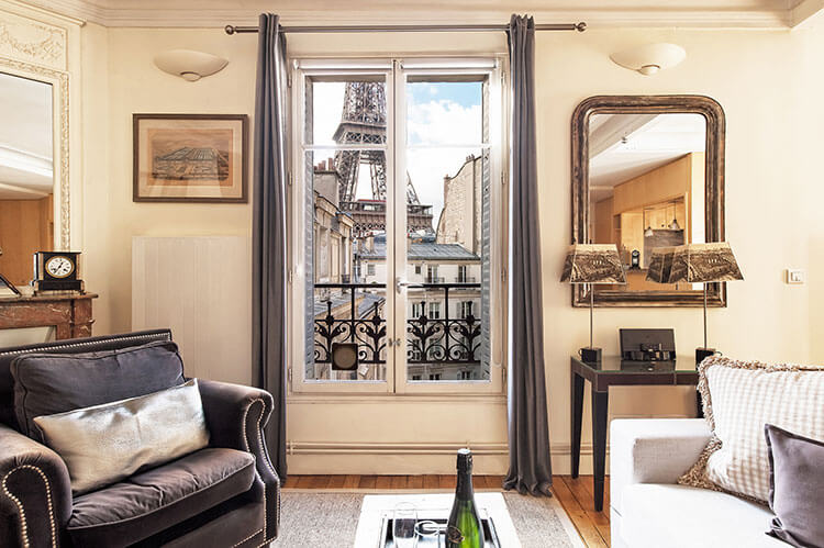 Paris Perfect vacation apartment living room decorated in beige tones with a view of the Eiffel Tower