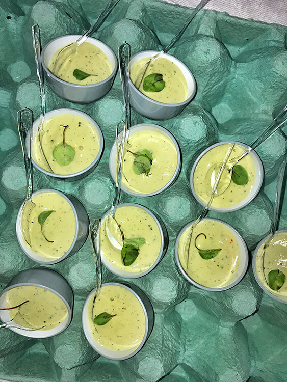 Creamy basil egg served in egg cups in an egg crate
