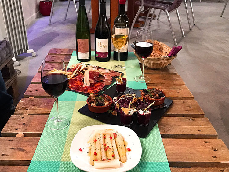 White asparagus with pomegranite, a charcuterie plate, and a plate with hummus, octopus salad, and couscous paired with three natural wines at Comptoir St. Vincent Natural Wine Bar