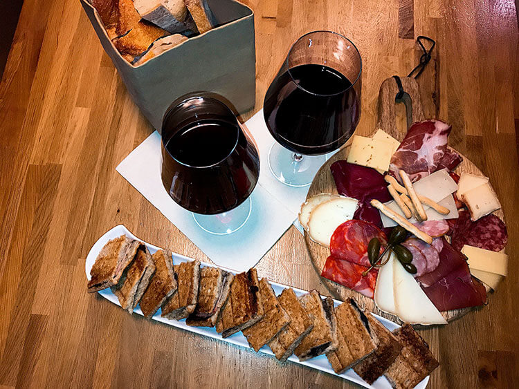 A platter with the truffle croque monsieur, a charcuterie plate and two glasses of wine at Vins Urbains