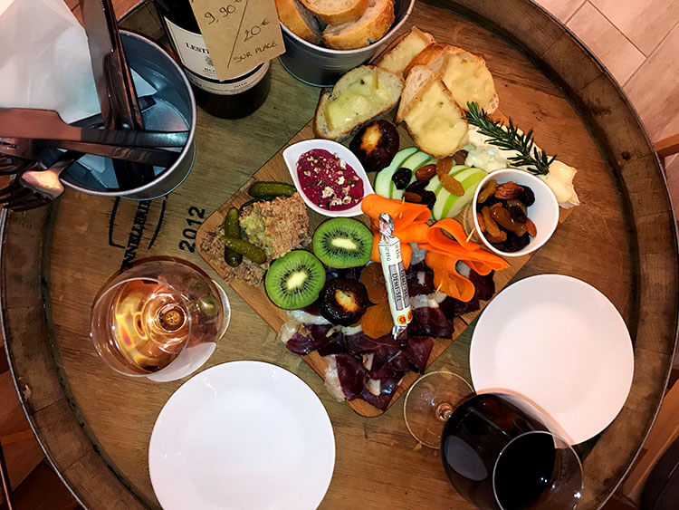 A charcuterie board with kiwi, apples, carrots, hummus, cheese and smoked duck at Un Chateau en Ville wine bar in Bordeaux