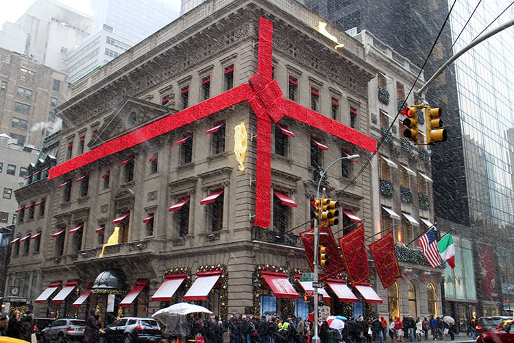 The Cartier building is wrapped up like a giant giftwrapped box with strings of red lights forming a bow