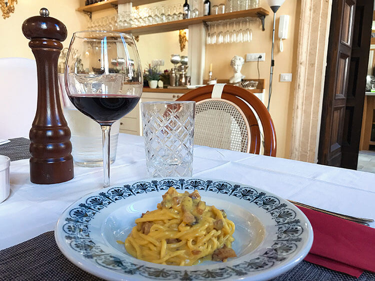 Enjoying carbonara with a glass of wine at In Rome Cooking