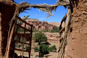 Ait-Ben-Haddou seen from the modern village through a gate made of wood and straw