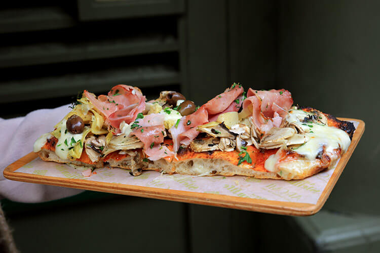 Aromi's famous sourdough pizza topped with artichoke, mushrooms, Parma ham and olives