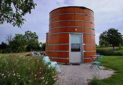 Two giant wine vats sit next to the vines at Château de Bonhoste