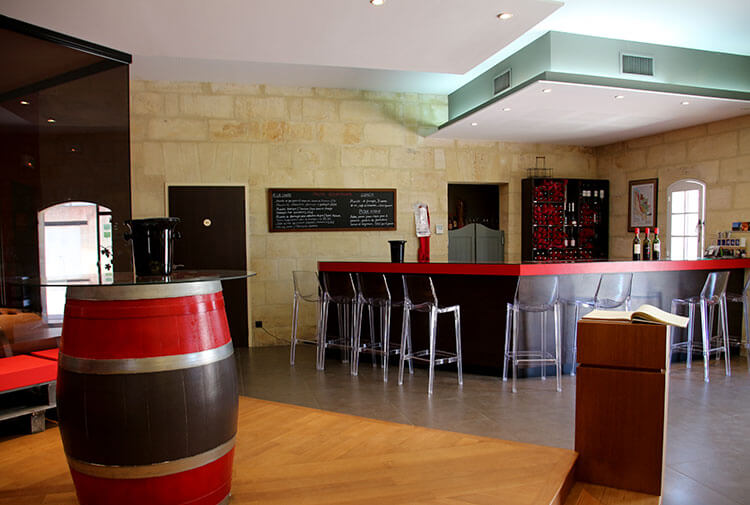 The tasting room and boutique is modern with clear plastic bar stools and a glass wall that looks in to the barrel room 