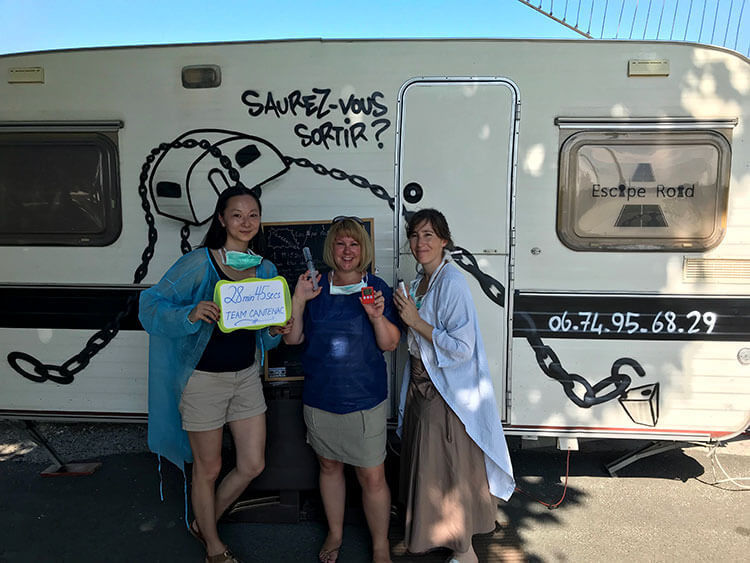 Jennifer and two friends dressed up as doctors and posing in front of the mobile escape room game at the Bordeaux Food Truck Festival 