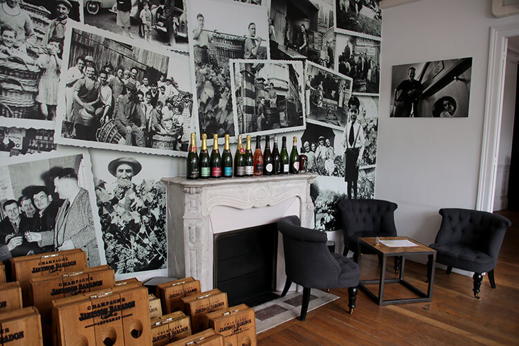The tasting room at Janisson Baradon is wallpapered with historic family photos and a fireplace makes it cozy