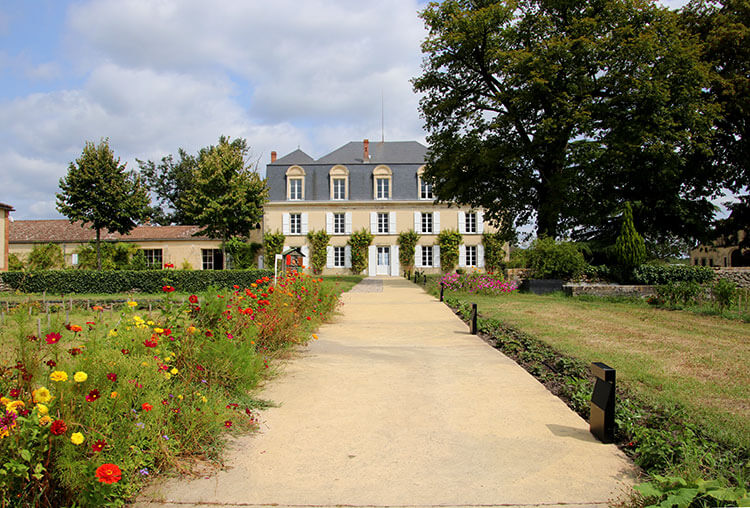 A long paved walkway leads to the main chateau and is lined with beds of marigolds