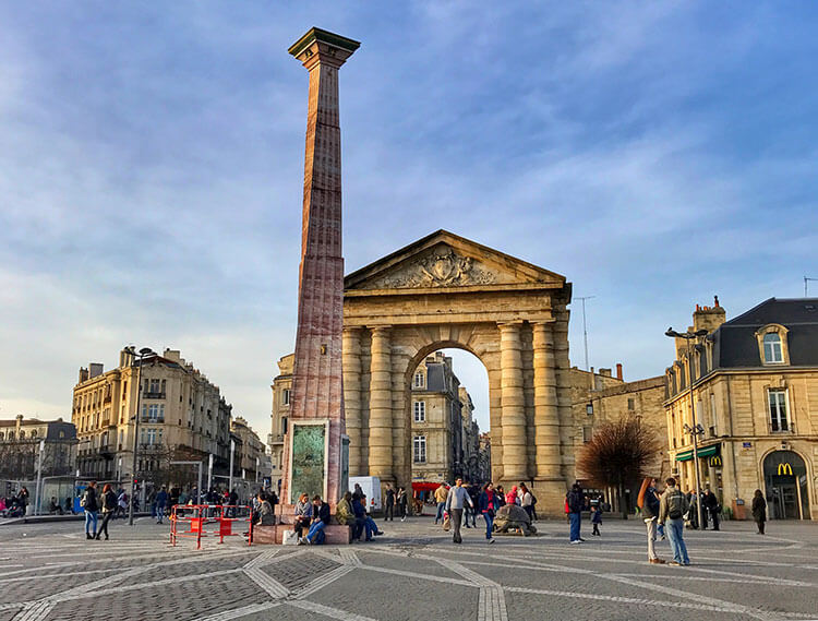 An obelisk in red marble and entrance gate stands on Place de Victorie