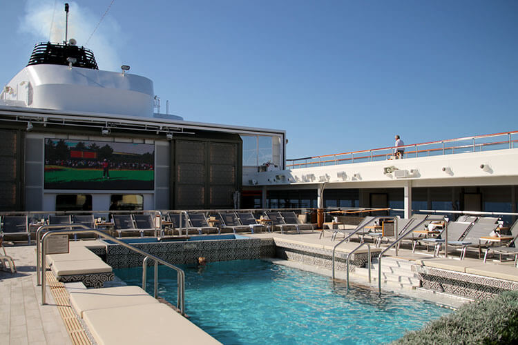 The main pool with the retractable roof open and the screen behind the pool where movies are shown