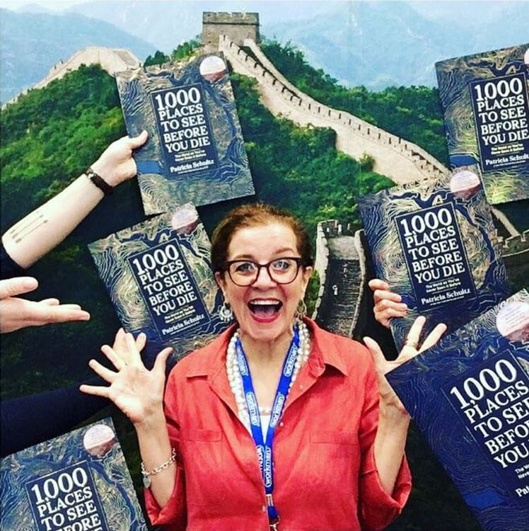 Patricia Shultz, author of 1000 Places to See Before You Die, stands on the Great Wall of China with her new hard cover coffee table book