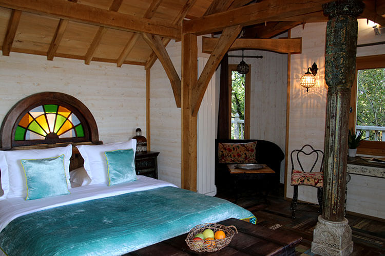 The bed with silk green linens in Cabane Monbazillac