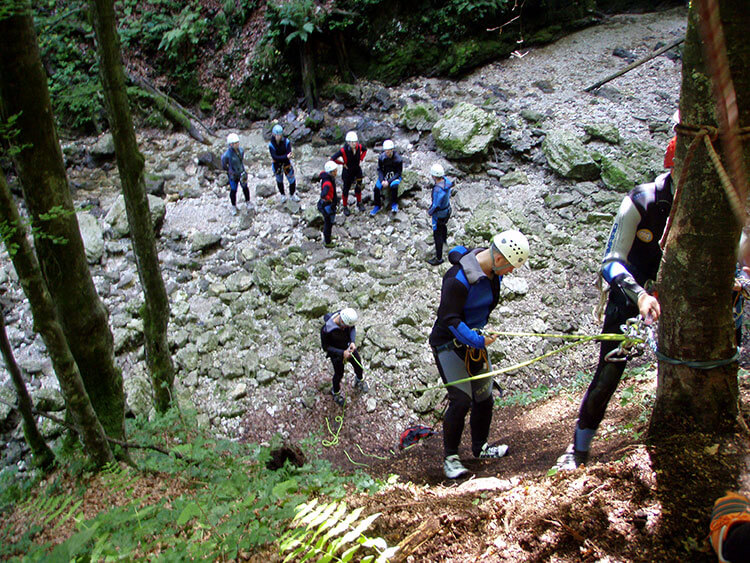 Learning to repel down from a tree at the start of the trail while canyoning in Lake Bled