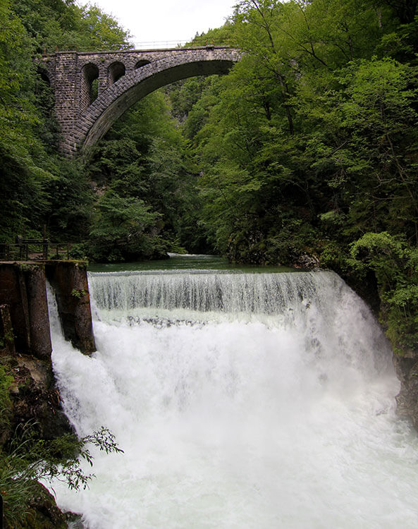 The Sum Waterfalls spills over in several tiers beneath a railroad bridge at the end of Vintgar Gorge