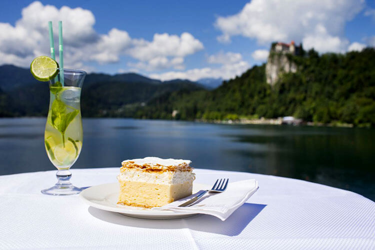 A piece of the original Bled cake with a view of Bled Castle at The Panorama Restaurant in Lake Bled 