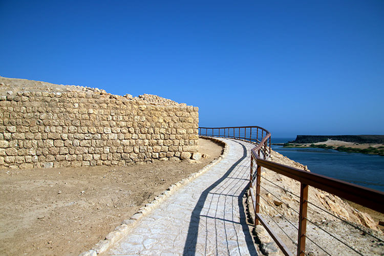 A walkway slopes up along the eastern foundation walls of Khor Rori