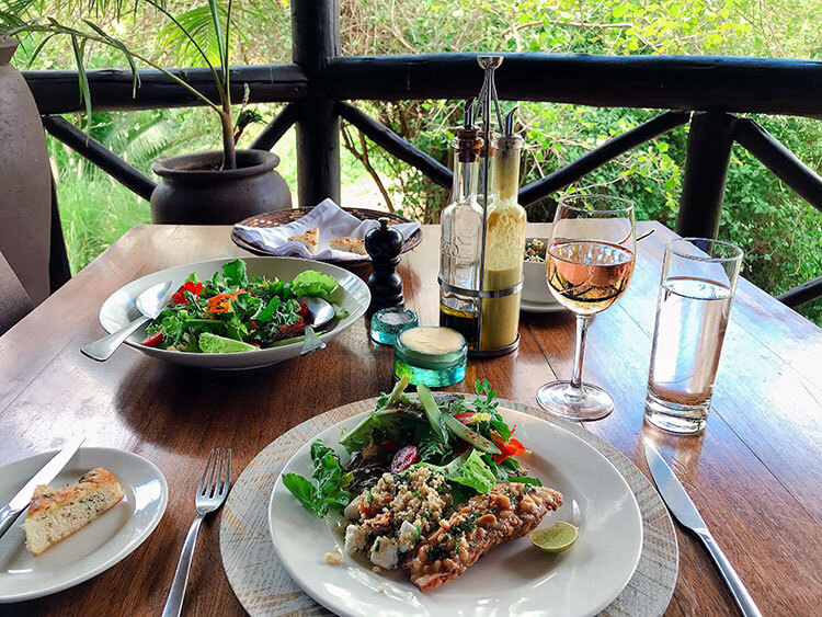 Lunch at The Emakoko with cashew crusted red snapper, garden salad with edible flowers and a glass of rosé wine