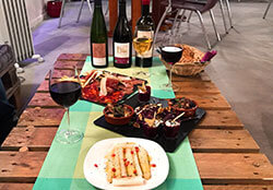 White asparagus with pomegranite, a charcuterie plate, and a plate with hummus, octopus salad, and couscous paired with three natural wines at Comptoir St. Vincent Natural Wine Bar