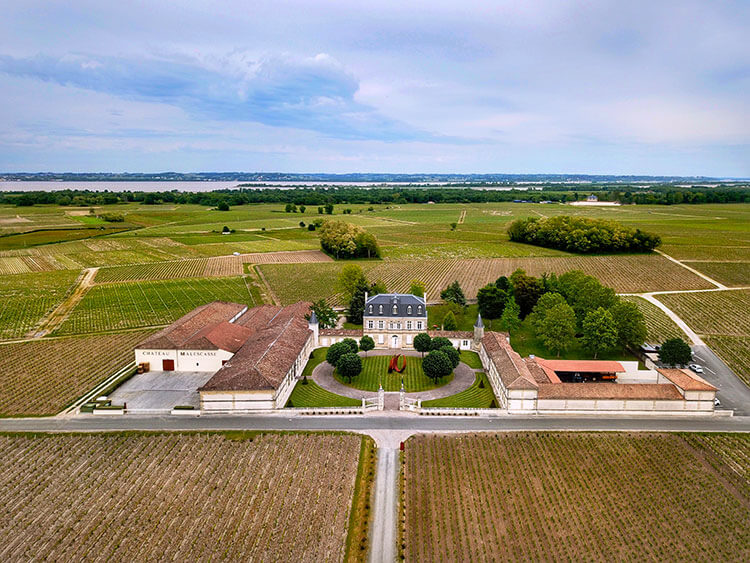 A drone aerial of Château Malescasse with the Gironde Estuary visible behind the vines