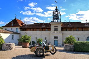 The Ural sidecar motorcycle parked in front of Château Angélus with their iconic bells