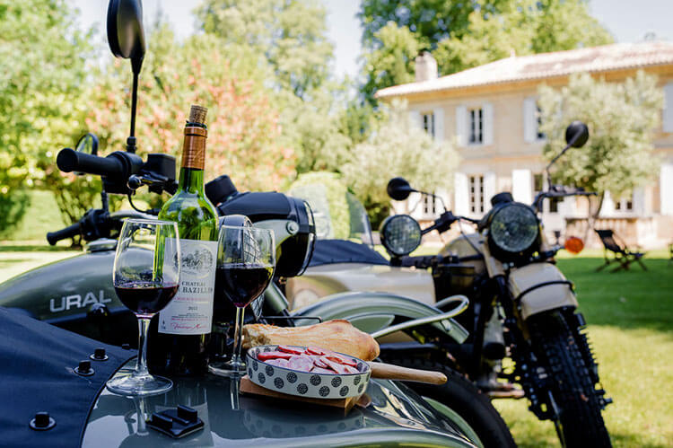 A bottle of wine with charcuterie is set up on the Ural motorcycle sidecar to enjoy along the tour through Saint-Emilion