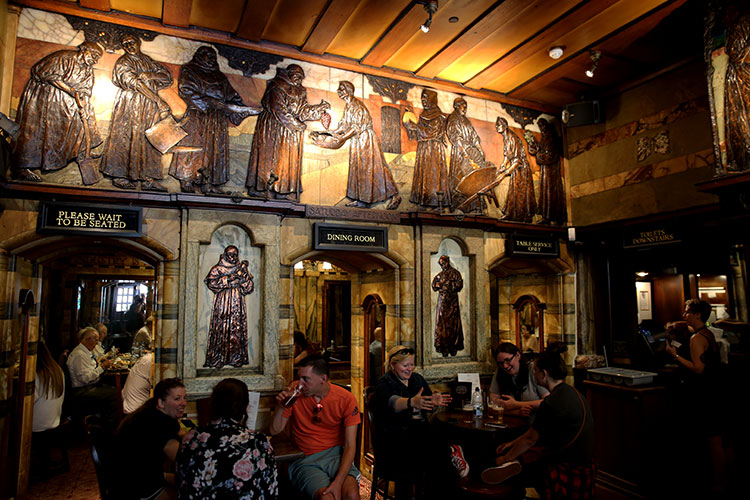 Wood panel reliefs adorn every wall with jolly monks inside the Blackfriar Pub 
