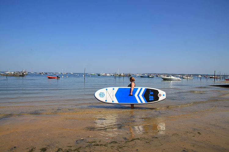 Jennifer carrying the iSUP board to the water in Cap Ferret