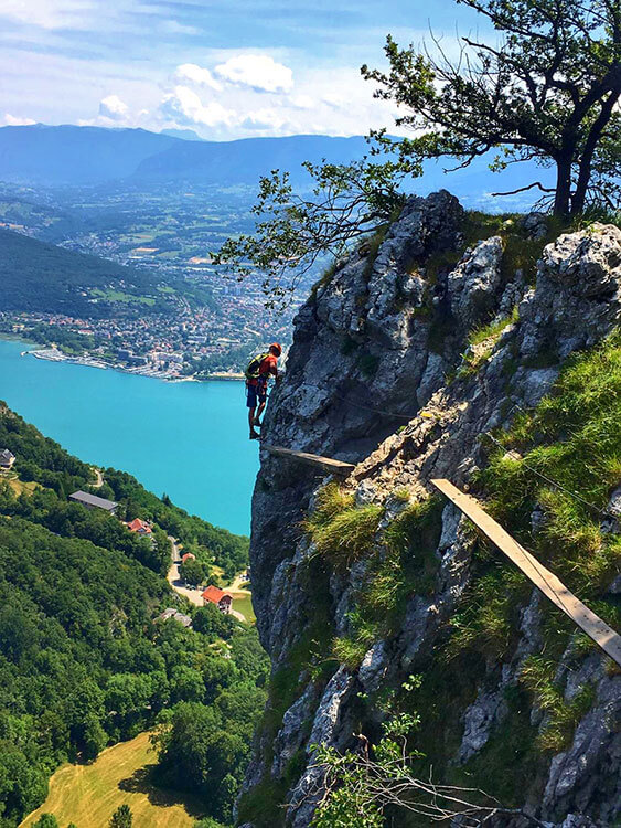 A climber clings to the cliff above Lake Bourget on the Via Ferrata Roc du Cornillon in Eastern France