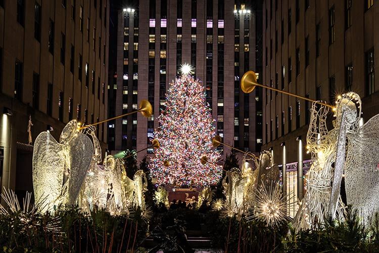 Angels blowing bugles lead to the Rockefeller Center Christmas Tree on Rockefeller Plaza in NYC