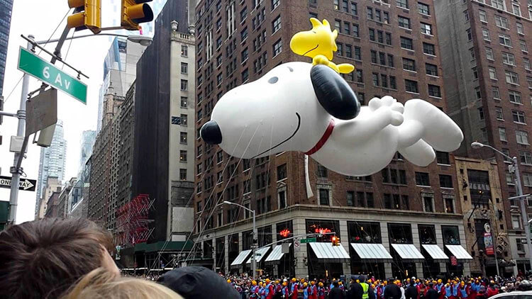 The Snoopy balloon passes by The Wayfarer during the Macy's Thanksgiving Day Parade in NYC