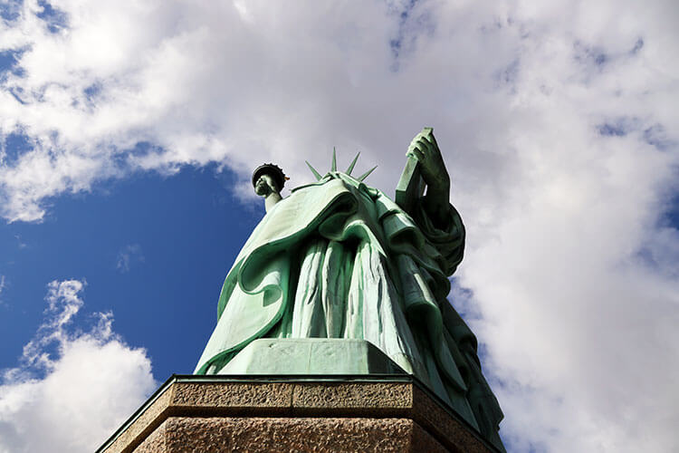 Looking up at the Statue of Liberty from on the pedestal with just some billows of the robe and the torch visible from this close perspective