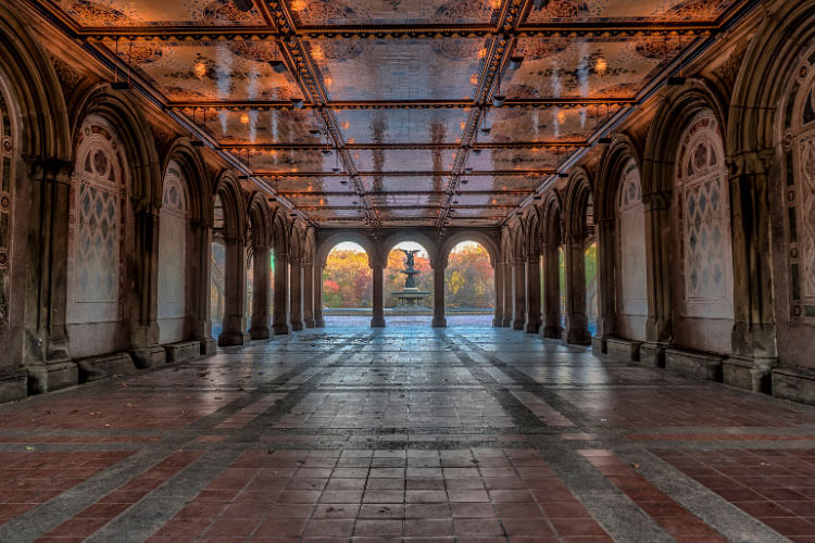 The arcade of the Bethesda Terrace with the fountain visible through the arches in Central Park