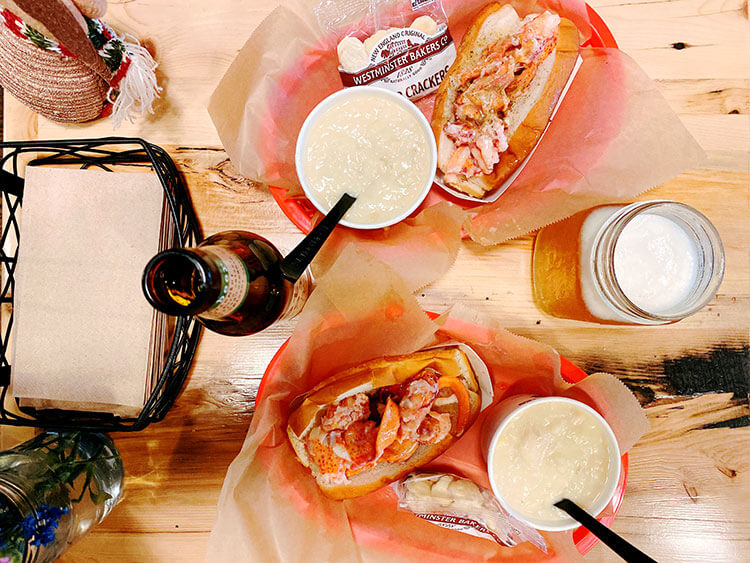 Lobster roll in a basket with a side cup of clam chowder at Luke's Lobster in NYC